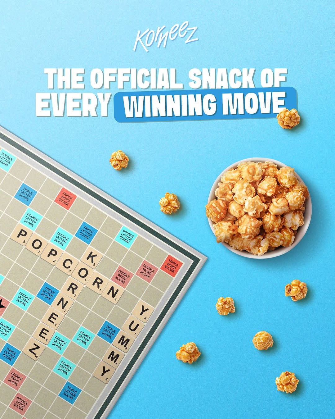 Korneez popcorn beside a Scrabble board spelling popcorn, Korneez, and yummy